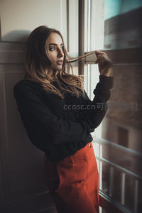 黑衣女子倚窗凝望远方