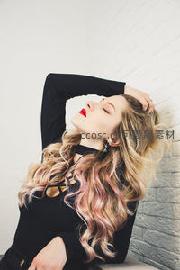 卷发红唇美女倚墙闭目享受时光