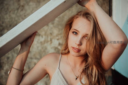 金发少女倚靠木梁凝视镜头