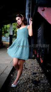 波点裙女孩在旧火车旁摆拍