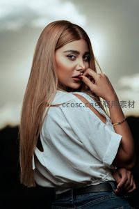 长发女子回眸凝视，白色露肩装显柔美