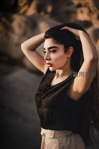 岩石背景下的沉思女子