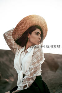 宽檐草帽下的优雅女子侧颜剪影
