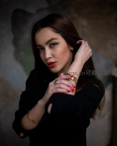 优雅女性佩戴金色珠宝凝视镜头