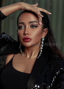 优雅女性佩戴闪亮耳环凝视镜头