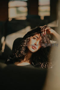 卷发女子在光影中沉思的瞬间