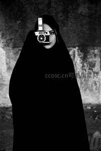 黑袍女子手持相机神秘凝视