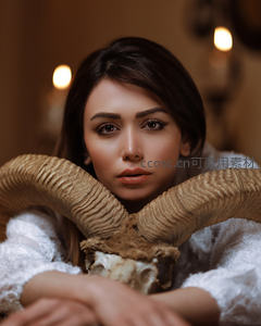 女子怀抱羊角骷髅凝视镜头