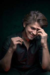 深绿背景下微笑的年轻男子