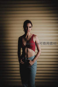 红衣女子在卷帘门前自信站立