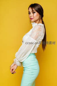 黄墙前蕾丝白衫的优雅转身