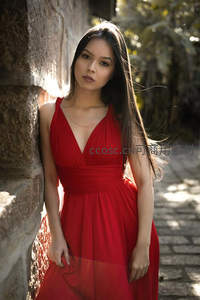 红裙女子倚古墙
