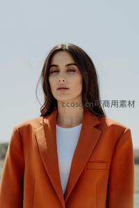 橙色西装女性，简约大气迎风而立