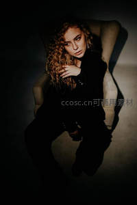 暗调光影中的卷发女子特写