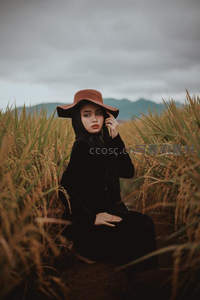 稻田中的优雅女子，戴着宽檐帽凝视远方