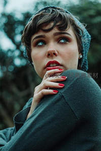 短发少女戴针织帽，红甲托腮望远方