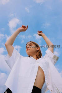 蓝天白云下白衣少女伸展双臂