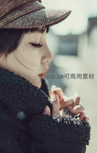 侧颜戴帽女子闭目沉思，毛绒围巾温暖冬日