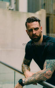 纹身男子倚栏凝视镜头