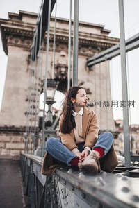 桥上沉思的少女，背景是宏伟的石桥塔楼