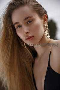 金发女郎佩戴华丽耳环，眼神迷人