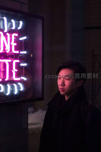 霓虹灯下凝视街头的青年