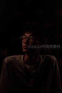暗光中戴眼镜青年侧颜，情绪深邃引人遐想