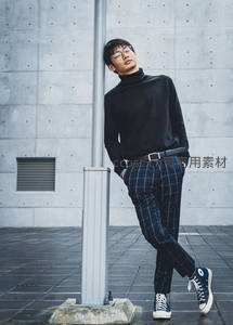 都市青年倚靠灯柱的时尚街拍瞬间