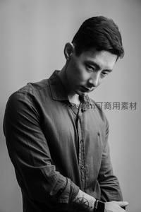 黑白影像中沉思青年低头看表