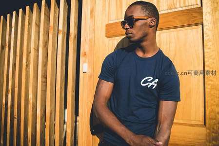 木墙前戴墨镜的潮男