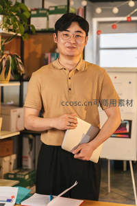 办公室内微笑的年轻商务人士手持文件