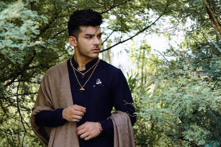 森林中身着传统服饰的英俊男子凝视远方