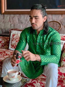 绿衣男子优雅品茶，享受悠闲午后时光