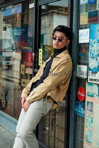 街头潮男靠橱窗，墨镜夹克尽显都市范儿