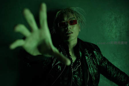 绿光中戴红镜青年伸手抓向镜头