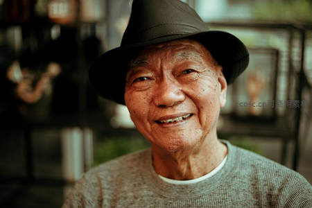 戴帽老人面带微笑展现岁月从容