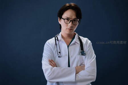 戴眼镜医生双臂交叉站立