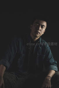 暗调光影下牛仔外套青年沉思