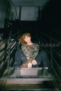 迷彩青年静坐楼梯间光影交错