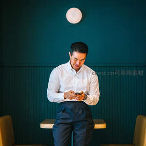 白衣男士深蓝背景低头看手机