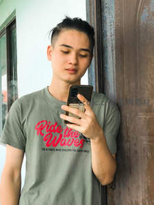 绿衣青年专注看手机自拍