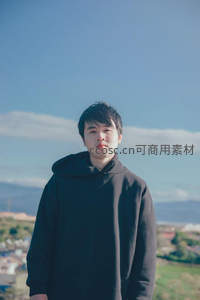 黑衣青年立于晴空下的远眺风景