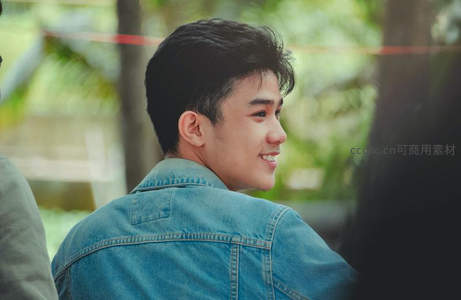 牛仔少年侧颜微笑，自然惬意瞬间