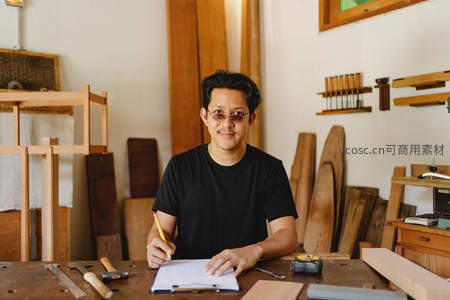 木匠在工作室专注绘制设计图纸