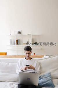 沙发上专注看手机的年轻人