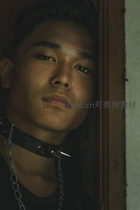 暗调光影下戴铆钉项圈的酷感青年