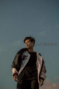 青年仰望天空，夹克随风轻扬
