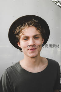 戴帽卷发青年微笑特写