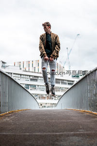 青年跃起于现代人行天桥之上