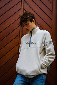 木墙前低头沉思的少年